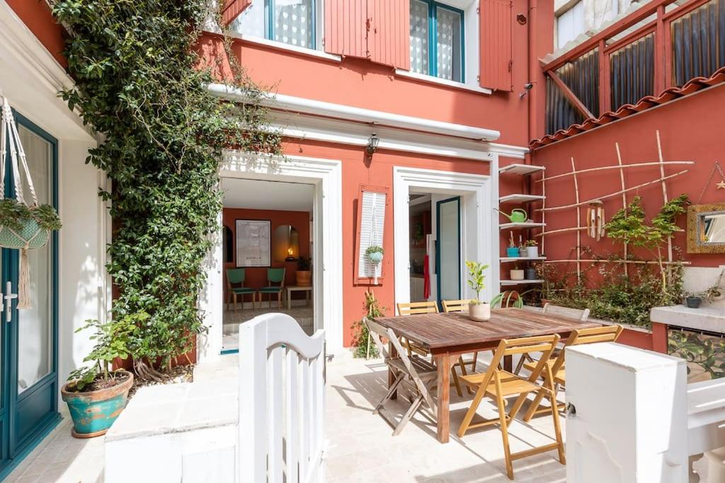 - patio z drewnianym stołem i krzesłami w obiekcie La petite Toscane de Marseille w Marsylii