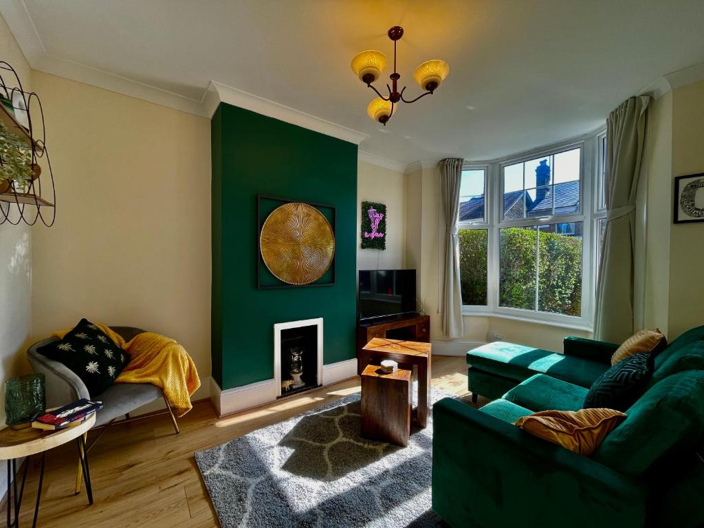 sala de estar con pared verde y sofá en Emerald Lodge Central 3 Bed Parking WI-FI Garden close to centre en Chelmsford