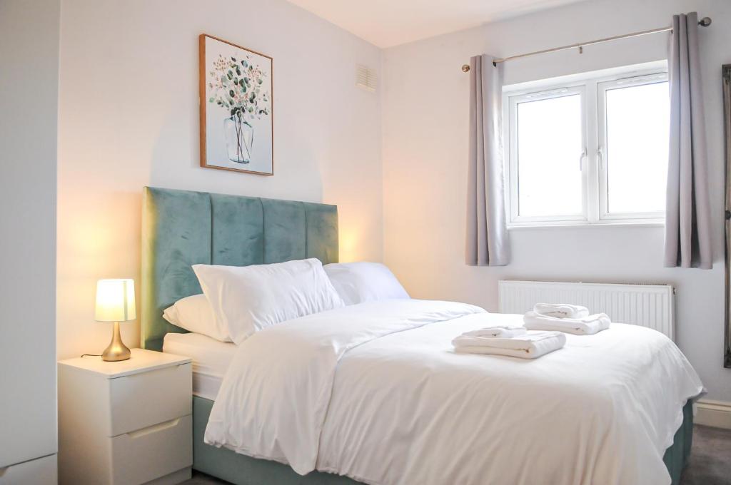 Un dormitorio con una gran cama blanca y una ventana en Luxury 5 Star London Apartment - Parking, Garden, nr Greater London Metro Stations, en Forest Hill