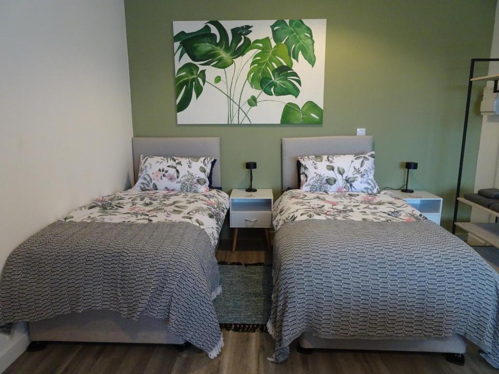 sypialnia z 2 łóżkami i obrazem na ścianie w obiekcie Modern Barn Conversion w mieście Brackley