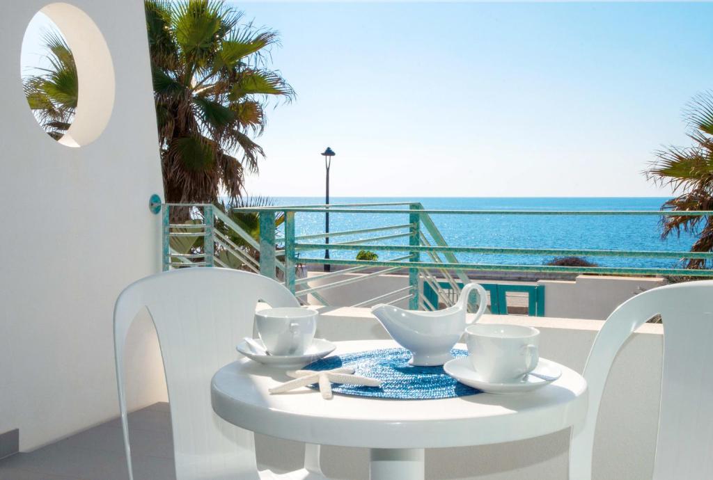 托雷蘇達的住宿－Terrazze Del Mare，白色的桌椅,享有海景