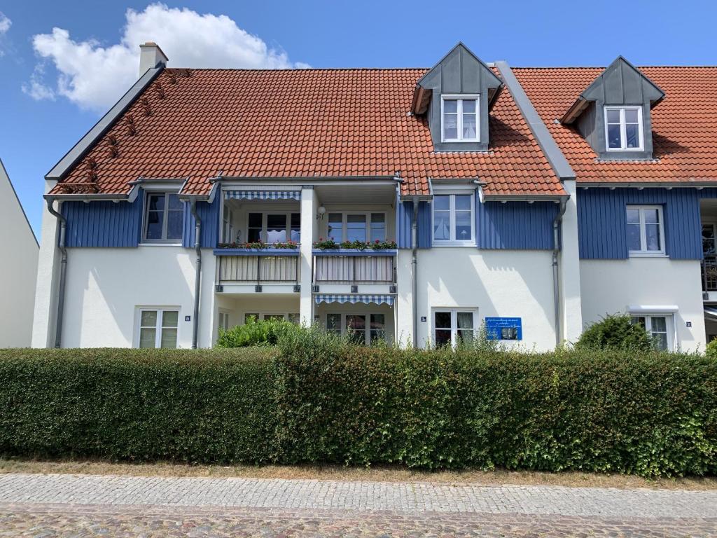 ein großes Haus mit einem roten und blauen Dach in der Unterkunft Wiecker Apartment am Ryck in Greifswald