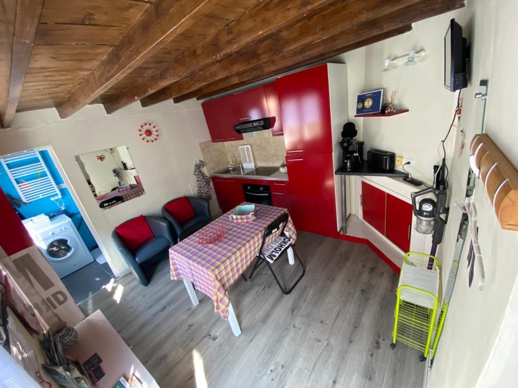 a kitchen with red cabinets and a table in a room at Le vieux logis in Étretat