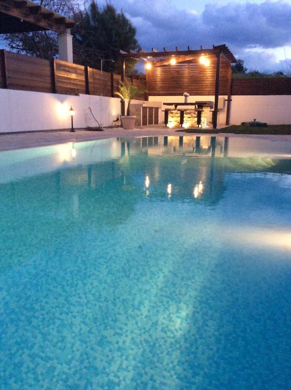 a large swimming pool at night with a house in the background at Dream House Latchi Villa in Polis Chrysochous