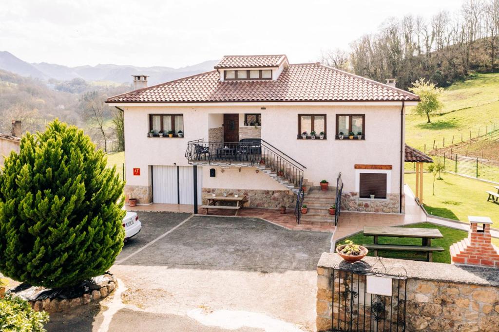 a house with a car parked in front of it at Apartamentos La Cortina in Cangas de Onís