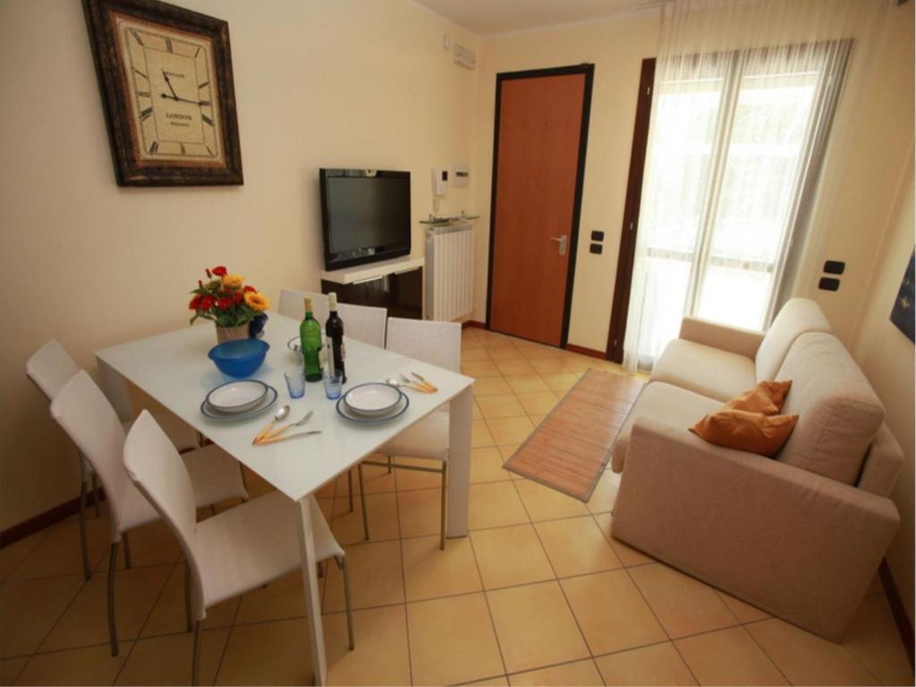 uma sala de estar com uma mesa branca e um sofá em Charming sea front view apartment-Beahost Rentals em Rosolina Mare
