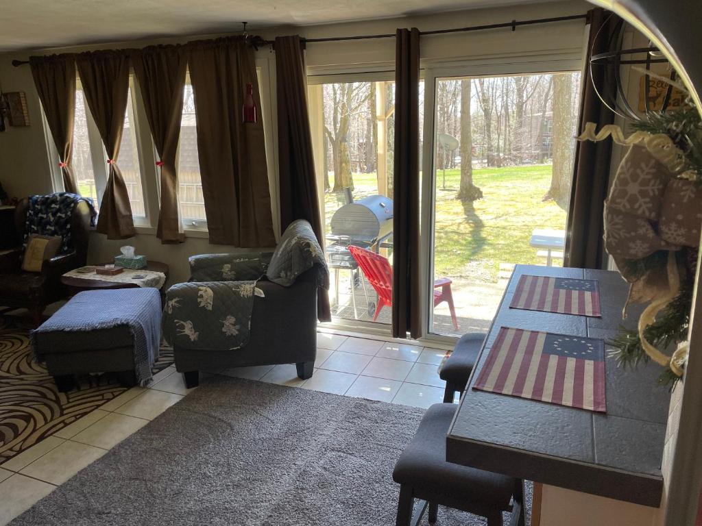 ein Wohnzimmer mit einem Sofa, einem Tisch und einem Fenster in der Unterkunft Blue Knob Bear Den (Nordic Center/Golf Course) in Claysburg