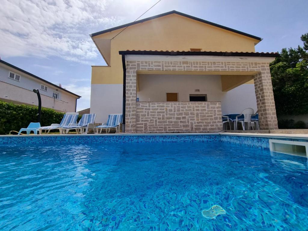 a swimming pool in front of a villa at ARA-ZAROK in Baška