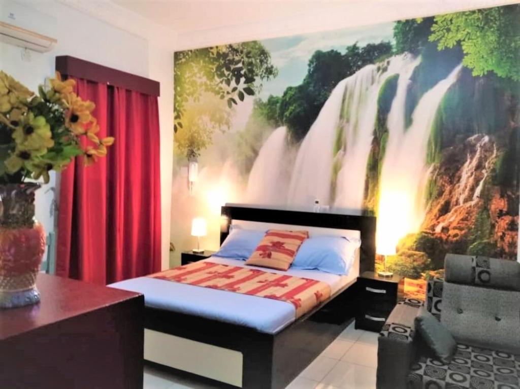 a bedroom with a large painting of a waterfall at Agreable Studio Meuble in Abidjan
