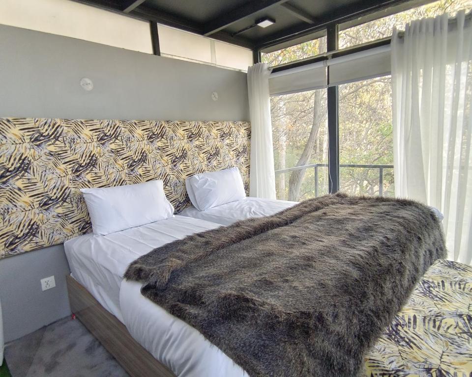 una camera da letto con un grande letto con una coperta sopra di Zihin with Forest view - Cloud Nine And a Half a Baltit