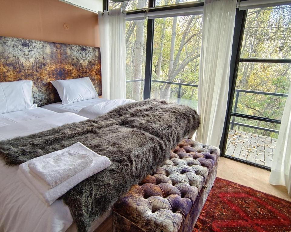 a bedroom with two beds and a large window at Kalp with Forest View- Cloud Nine and a Half Hunza in Hunza