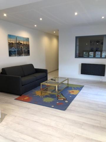 un salon avec un canapé et une table en verre dans l'établissement Marseille bleue, à Marseille