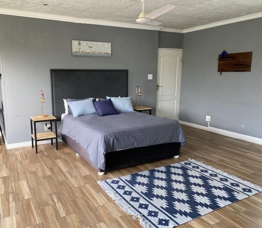 a bedroom with a large bed and a rug at 59 On Gail in Ballito