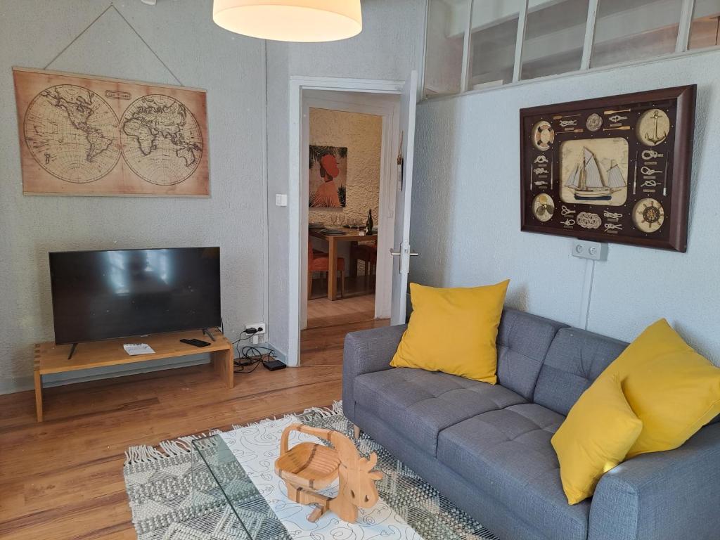 un salon avec un canapé bleu et une télévision dans l'établissement TY MA GOURDADOU, à Saint-Pol-de-Léon