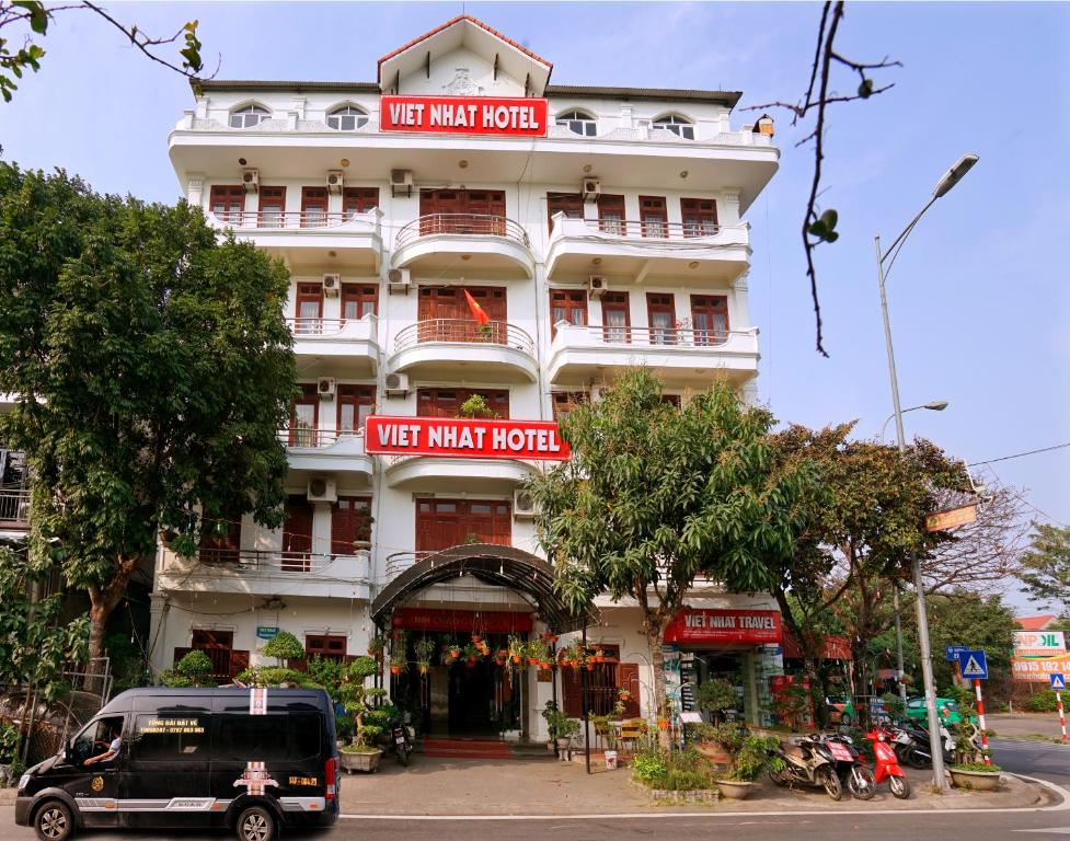 a large white building with red signs on it at Viet Nhat Hotel in Ninh Binh