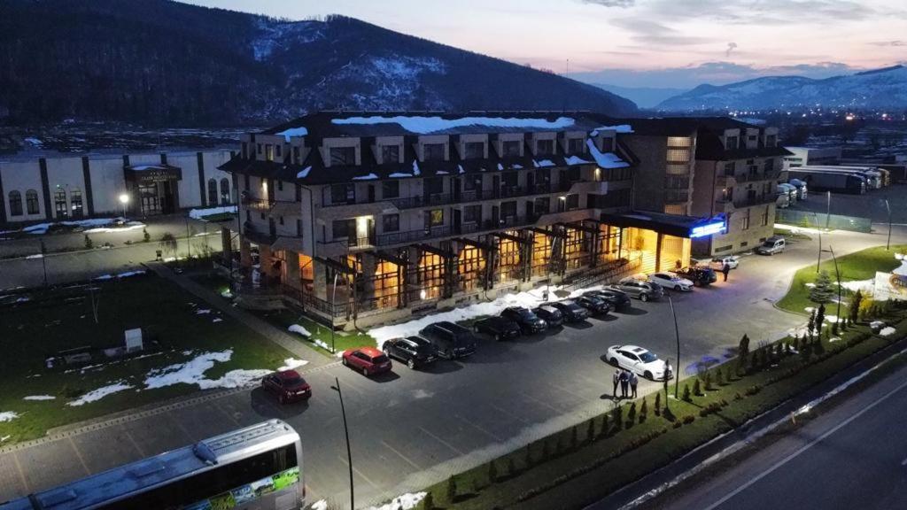 un gran edificio con coches estacionados en un estacionamiento en Hotel Club Bucovina Resort & Spa, en Gura Humorului