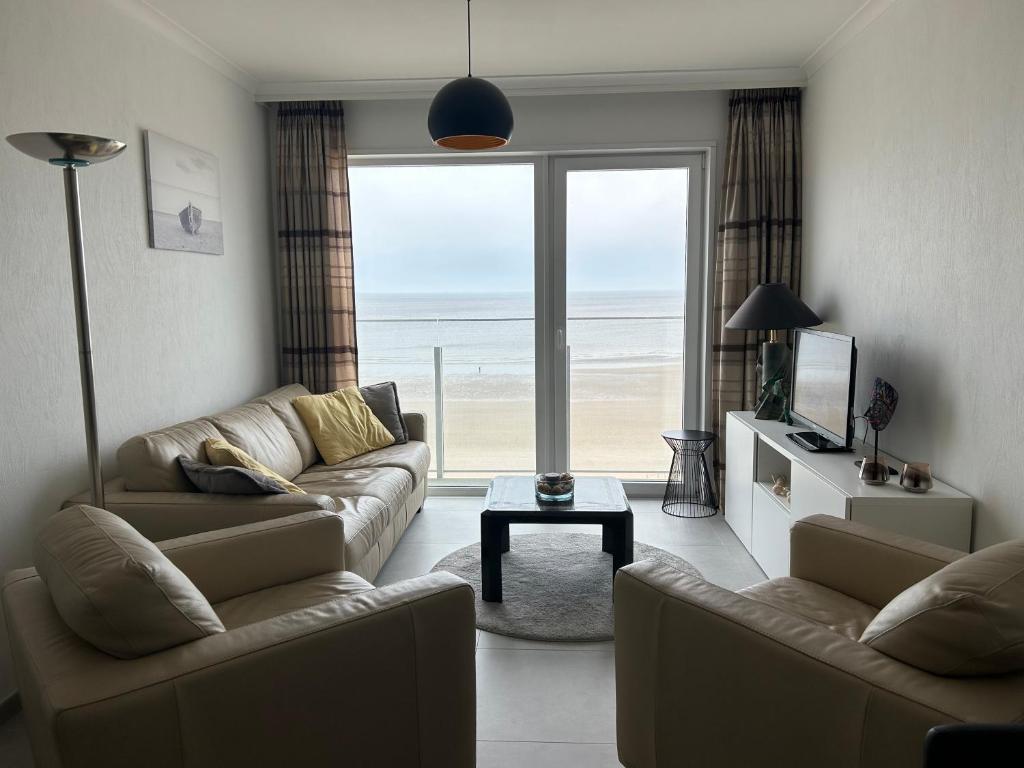 - un salon avec deux canapés et une vue sur l'océan dans l'établissement Appartement met 2 slaapkamers op zeedijk Middelkerke, à Middelkerke