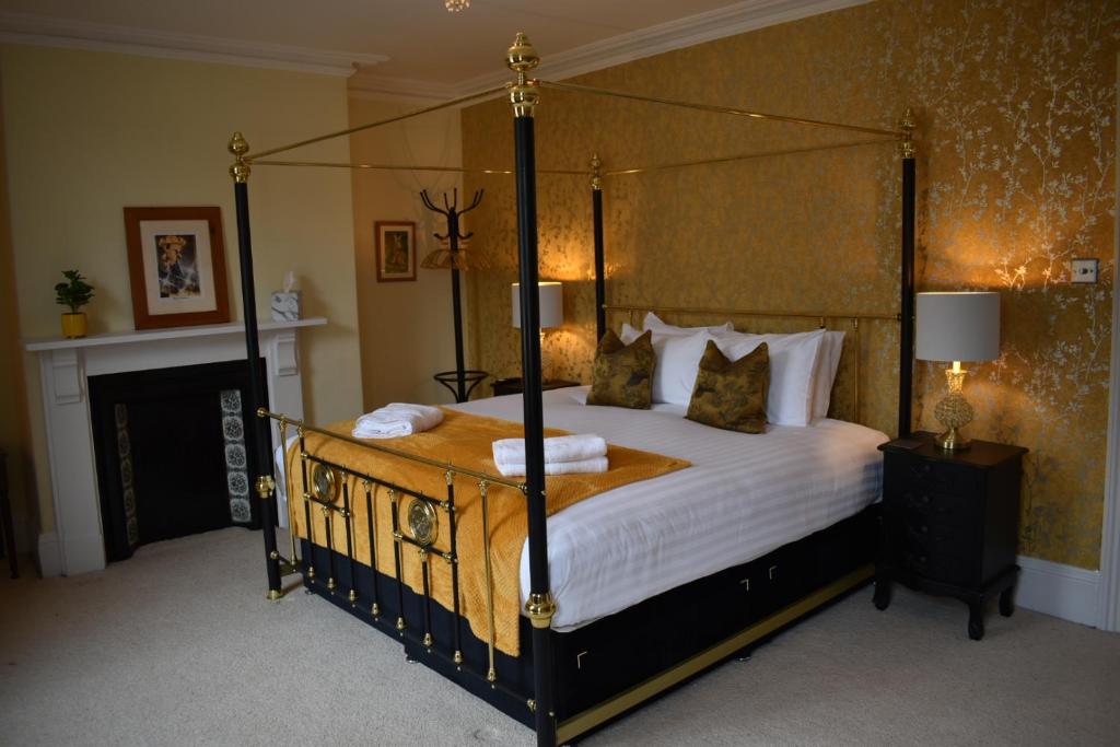 een slaapkamer met een hemelbed met witte lakens en kussens bij Carlton House - Spacious 4 Bed Victorian townhouse in Harrogate