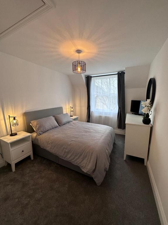 a bedroom with a large bed and a window at Beautiful house on the River Itchen in Winchester