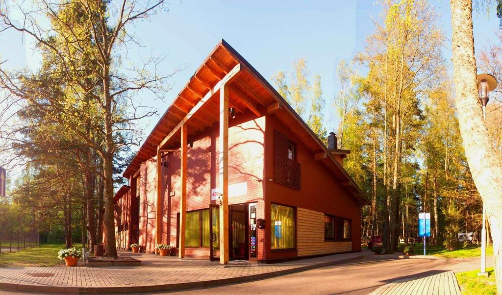 un gran edificio de madera con techo de gambrel en Pajūrio Kempingas en Klaipėda