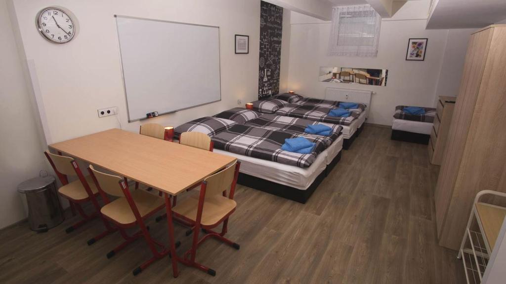 1 dormitorio con 1 cama, mesa y sillas en School Apartment - Your Unique Place in Prague by metro Vyšehrad, en Praga