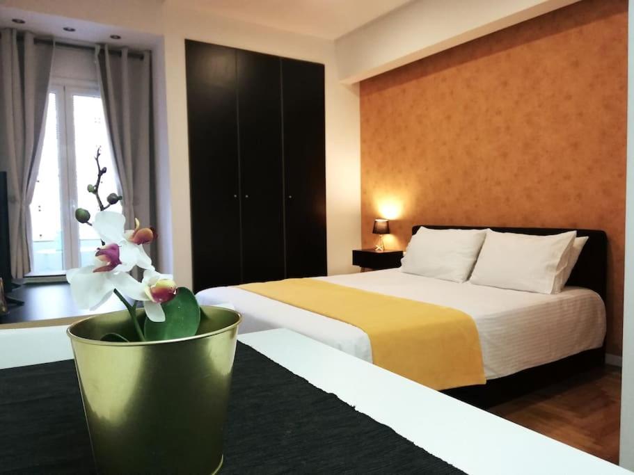 a hotel room with a bed and a vase with flowers at Modern flat in city center in Athens