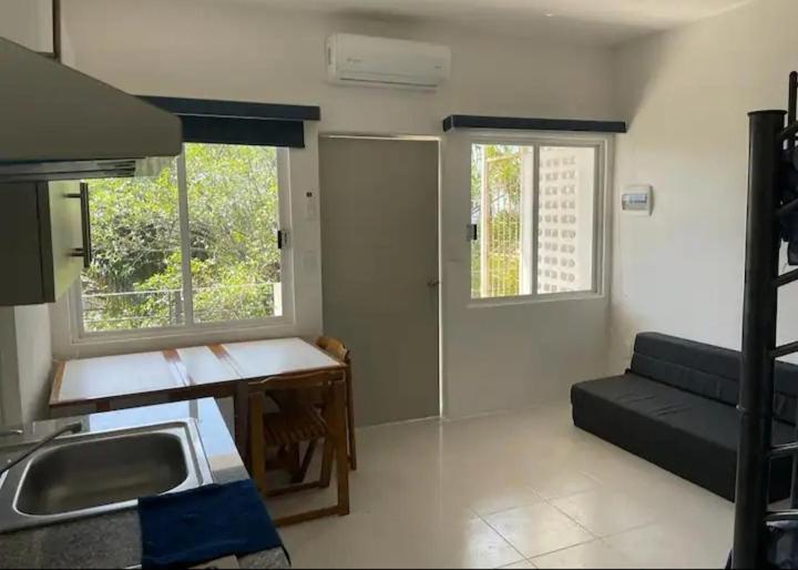 una cucina con lavandino e un divano in una camera di Loft 202 ad Acapulco