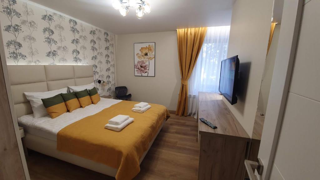 um quarto com uma cama grande e uma televisão de ecrã plano em DeMar Apart Sun em Kulʼparkuv