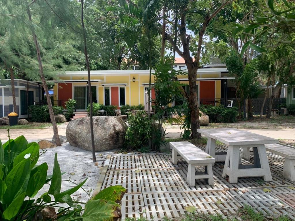 een picknicktafel en een bank voor een gebouw bij Rayonghouse Resort in Rayong