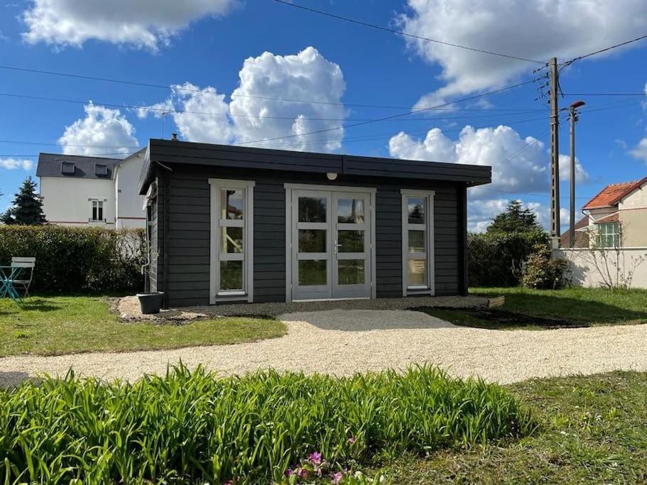 a tiny house with a garage in a yard at Tiny house toute équipée avec jardin in Saint-Florent-sur-Cher