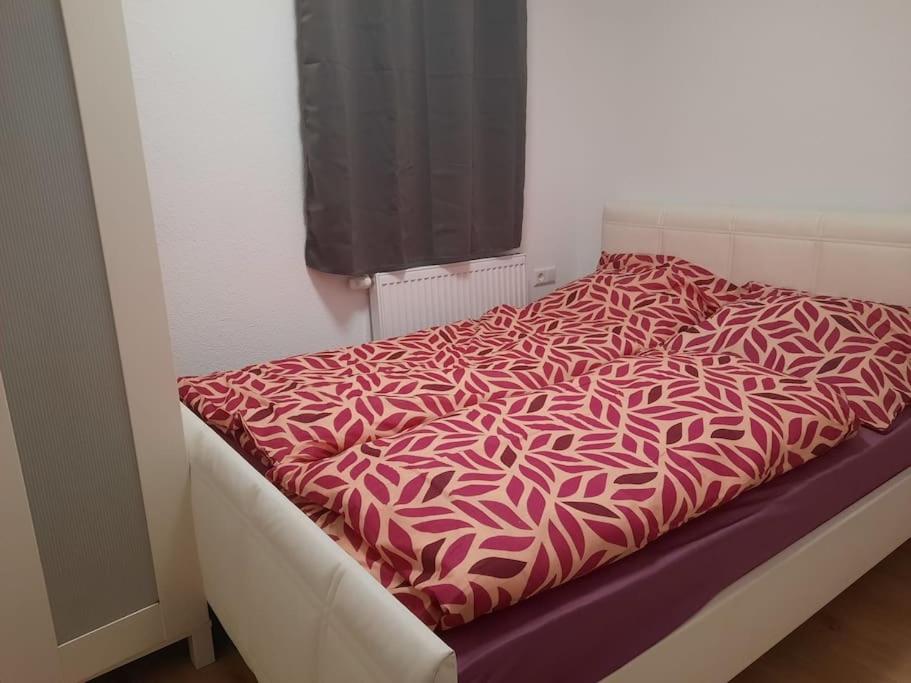 - un lit avec une couette rose et blanche dans l'établissement Gemütliche Wohnung in Happenbach, à Abstatt
