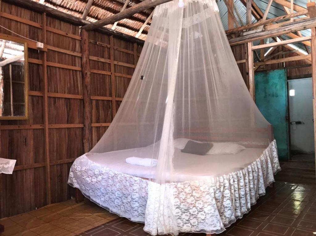 a bed in a room with a mosquito net at Tanjung Mefiyai Homestay in Fam