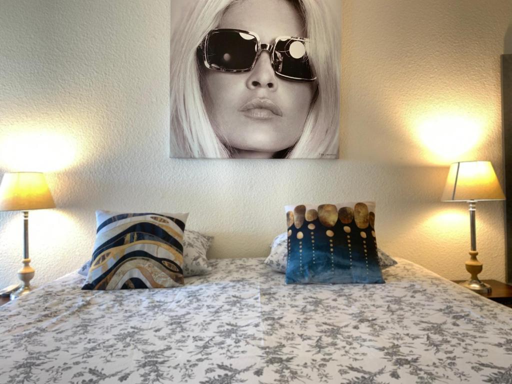 圣特罗佩BRIGITTE Studio centre Saint Tropez parking piscine wifi vue mer的一张床上戴着太阳镜的女人的照片