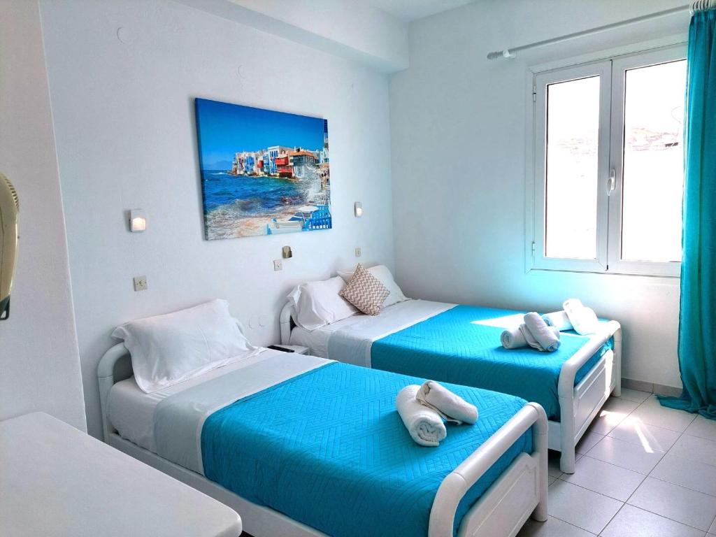 1 dormitorio con 2 camas y ventana en Seatincenter Rooms, en Mykonos ciudad