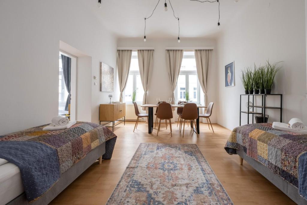 a bedroom with two beds and a dining room at ROKSOX-Home Meidling Schloss Schönbrunn in Vienna