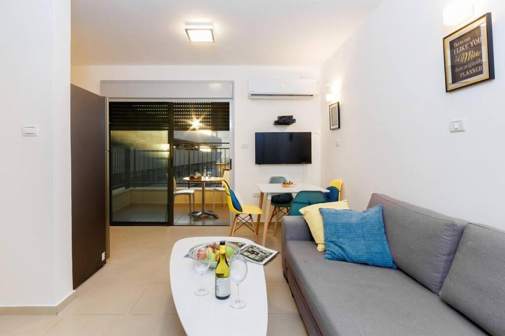- un salon avec un canapé et une table dans l'établissement Ben Yehuda Beach Appartment, à Tel Aviv