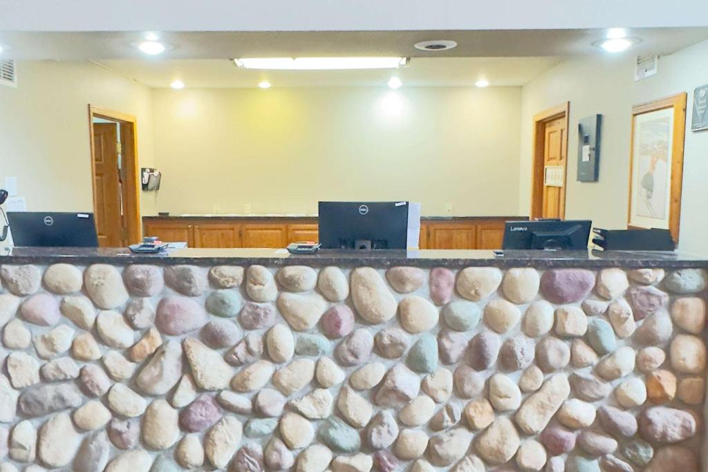 una pared de piedra frente a una sala de audiencias en Duluth Inn & Suites Near Spirit Mountain, en Duluth