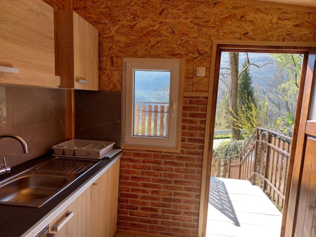 a kitchen with a sink and a window with a balcony at Mike's Rooms in Kobarid
