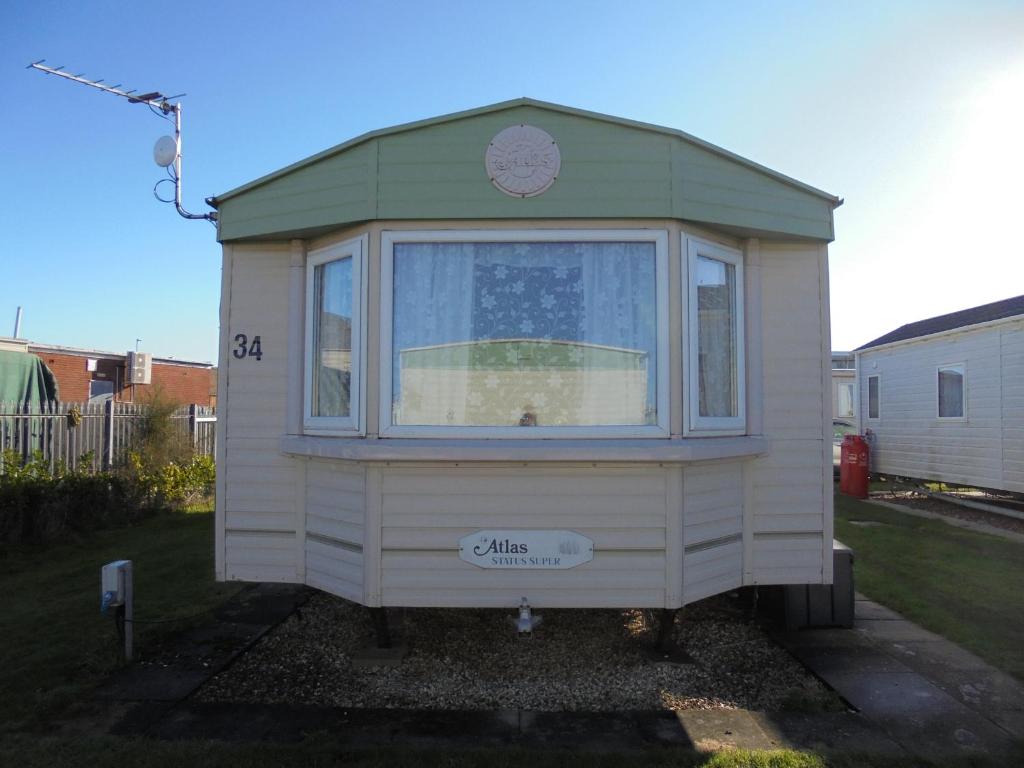 a small house with a window in a yard at 10 Berth on Coastfields with free WiFi Status in Ingoldmells