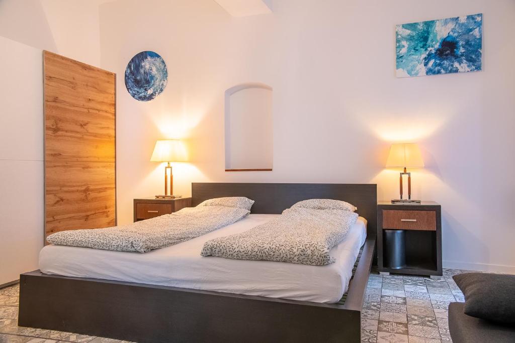 1 dormitorio con 2 camas y 2 lámparas en la pared en Family&Friends Apartments Schönbrunn en Viena