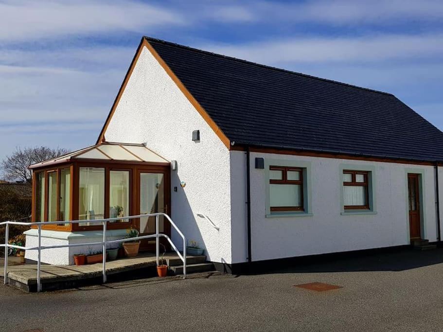 Cette petite maison blanche dispose d'une fenêtre et d'une terrasse couverte. dans l'établissement OneRavensLane, à Stornoway