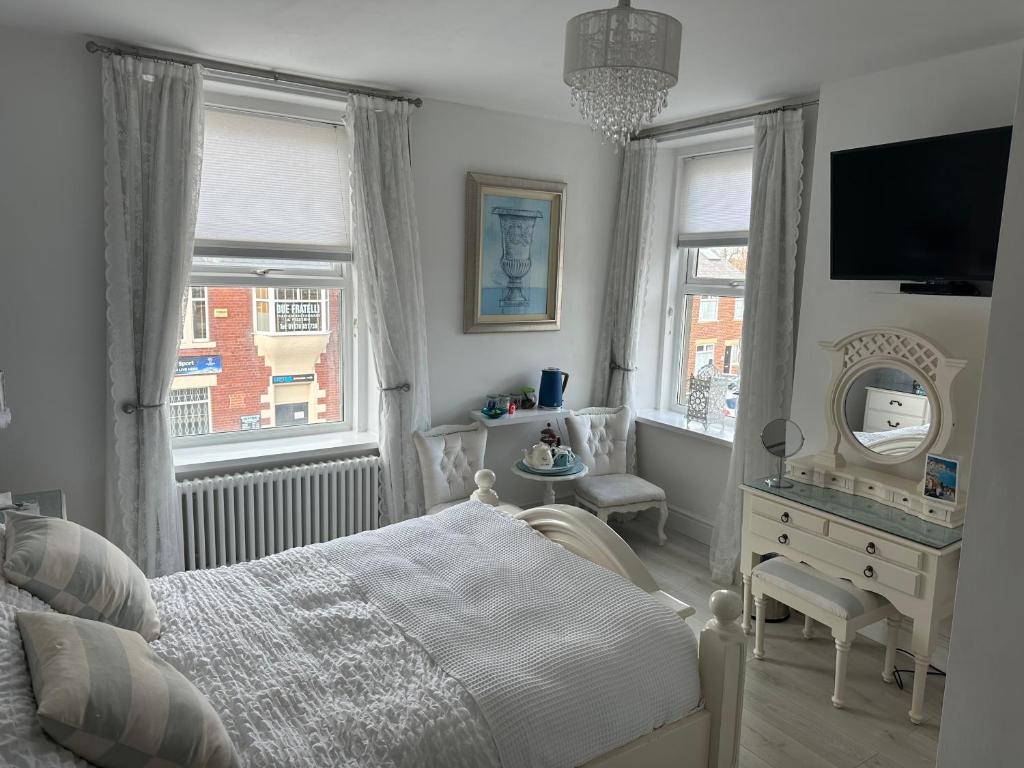 1 dormitorio con cama, tocador y espejo en Coastal Joy - Room 5, en Newbiggin-by-the-Sea