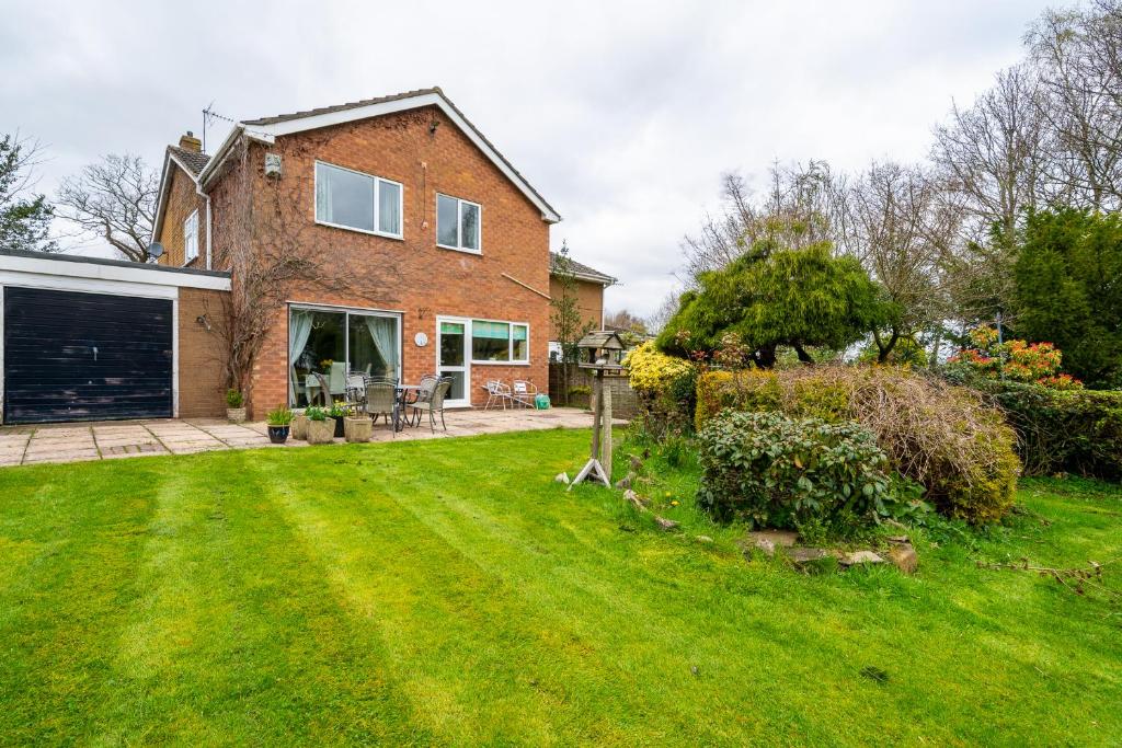 a large brick house with a yard with a grass yard at Jane & Julies place in Gresford