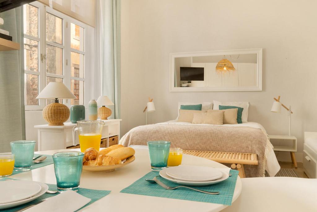 a white room with a bed and a table with food on it at Alcácer Flat in Alcácer do Sal