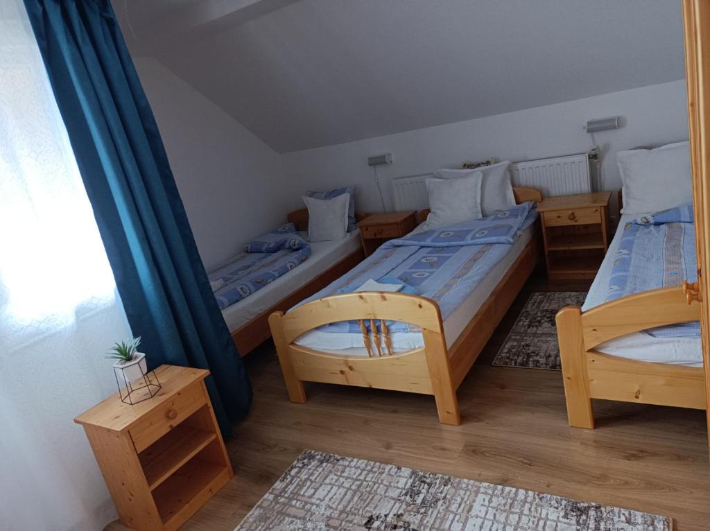 a bedroom with two beds and a mirror at Nárcisz B&B in Corund