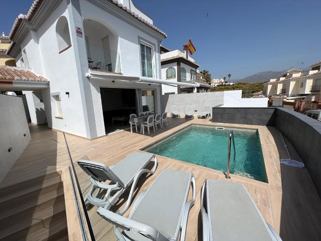 a swimming pool with chairs and a house at Villa Antonia Mar - Private Pool - Punta Lara Nerja in Nerja