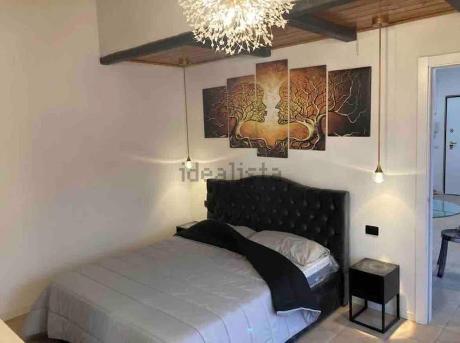 een slaapkamer met een groot bed en een kroonluchter bij Lilly’s Apartment Firenze in Florence