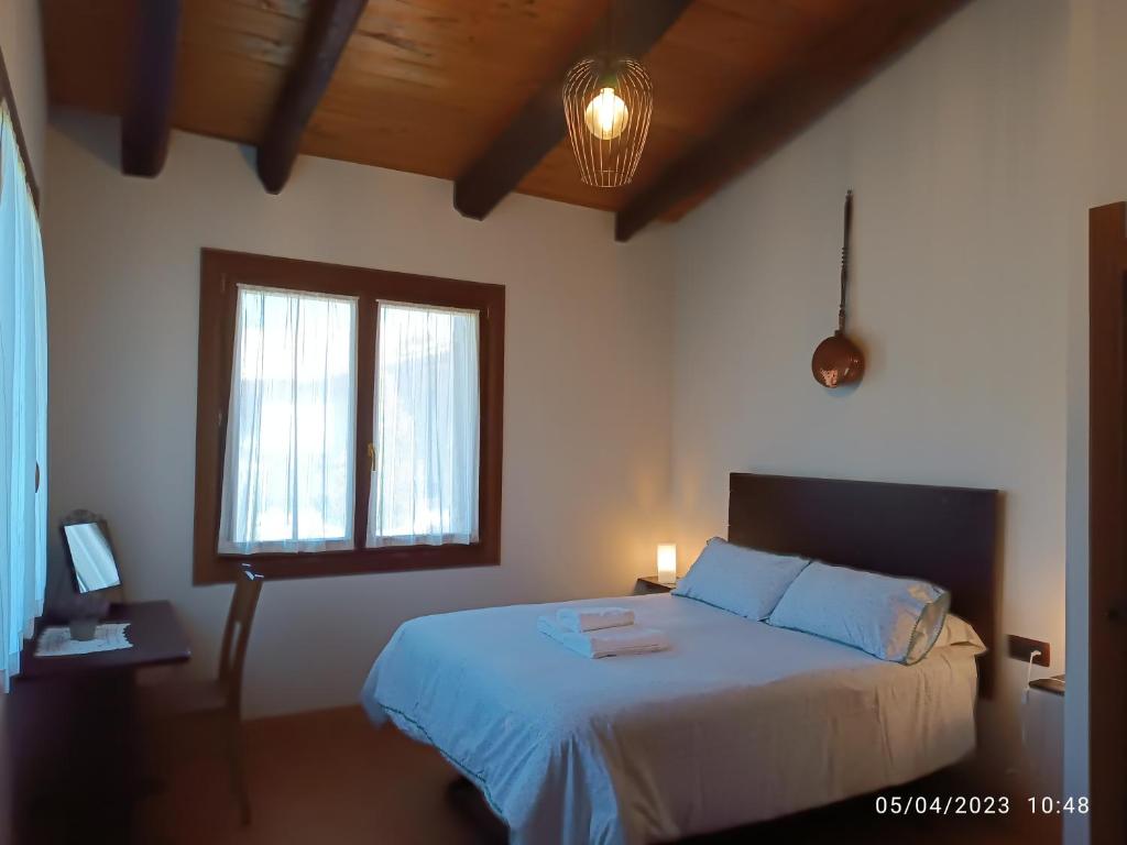 um quarto com uma cama com lençóis azuis e uma janela em Casa Rural Ubaba em Artaza