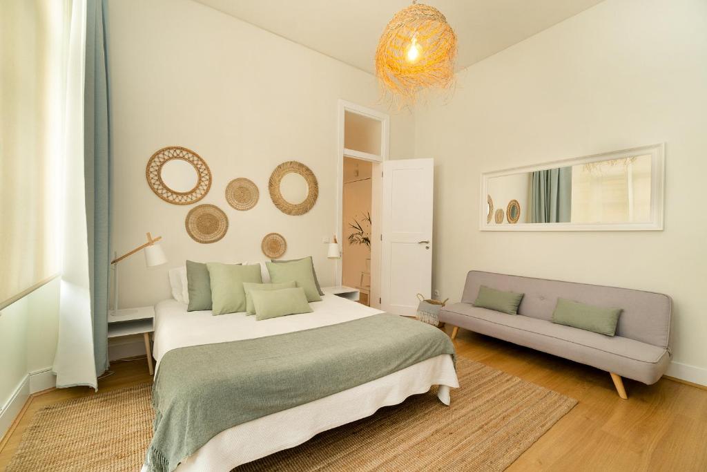 ein weißes Schlafzimmer mit einem Bett und einem Sofa in der Unterkunft Alcácer House in Alcácer do Sal