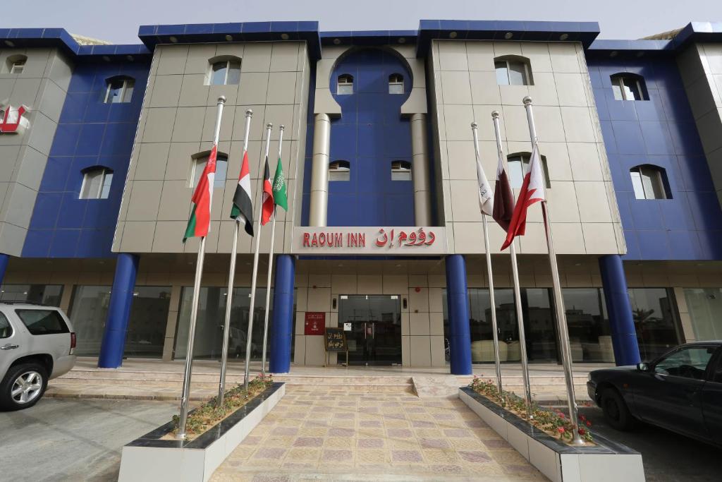 a building with a bunch of flags in front of it at Raoum Inn - Hawtah Bani Tamim in Hotat bani tamim